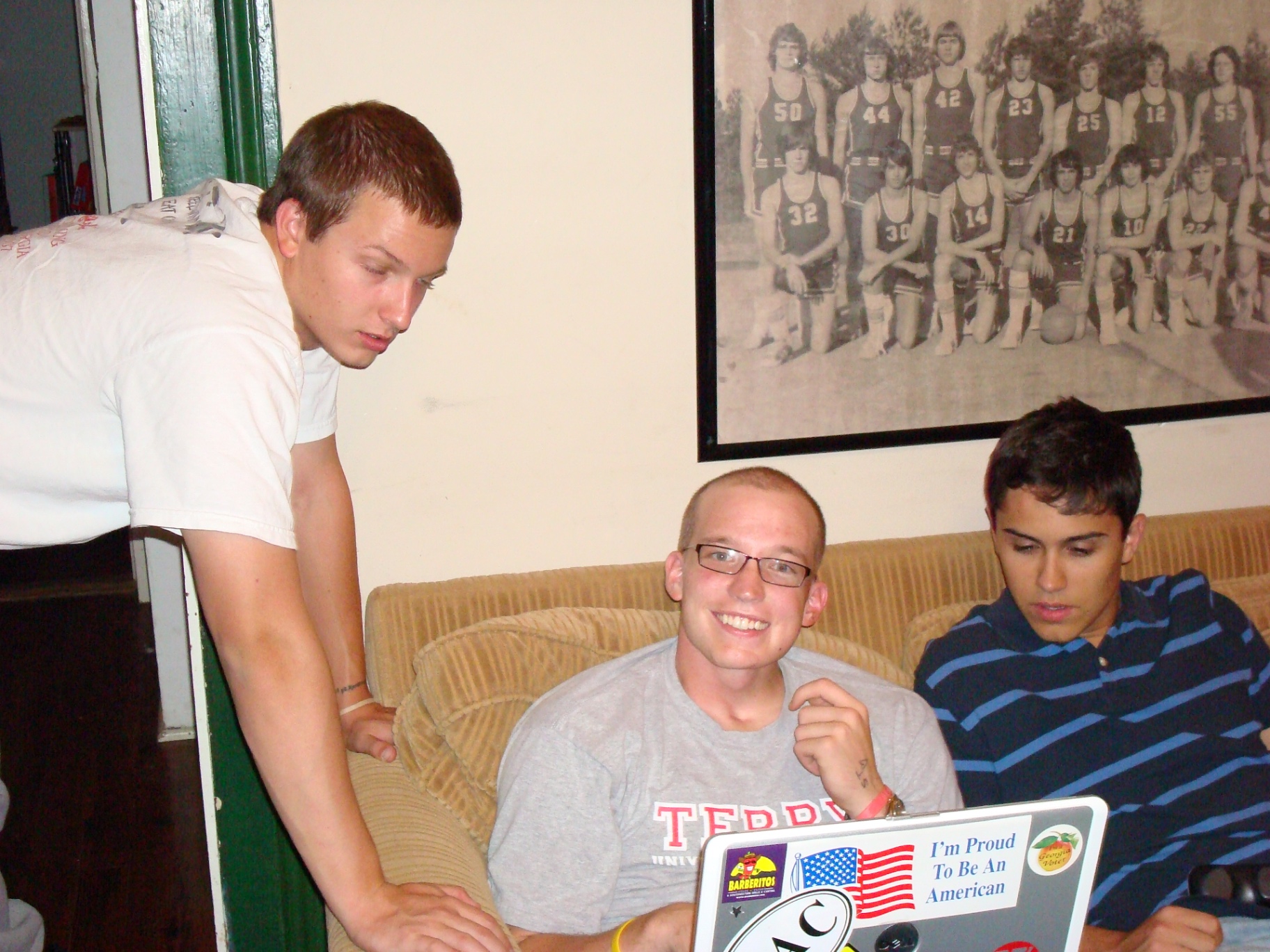Three guys hanging out around a laptop in the Springdale living room