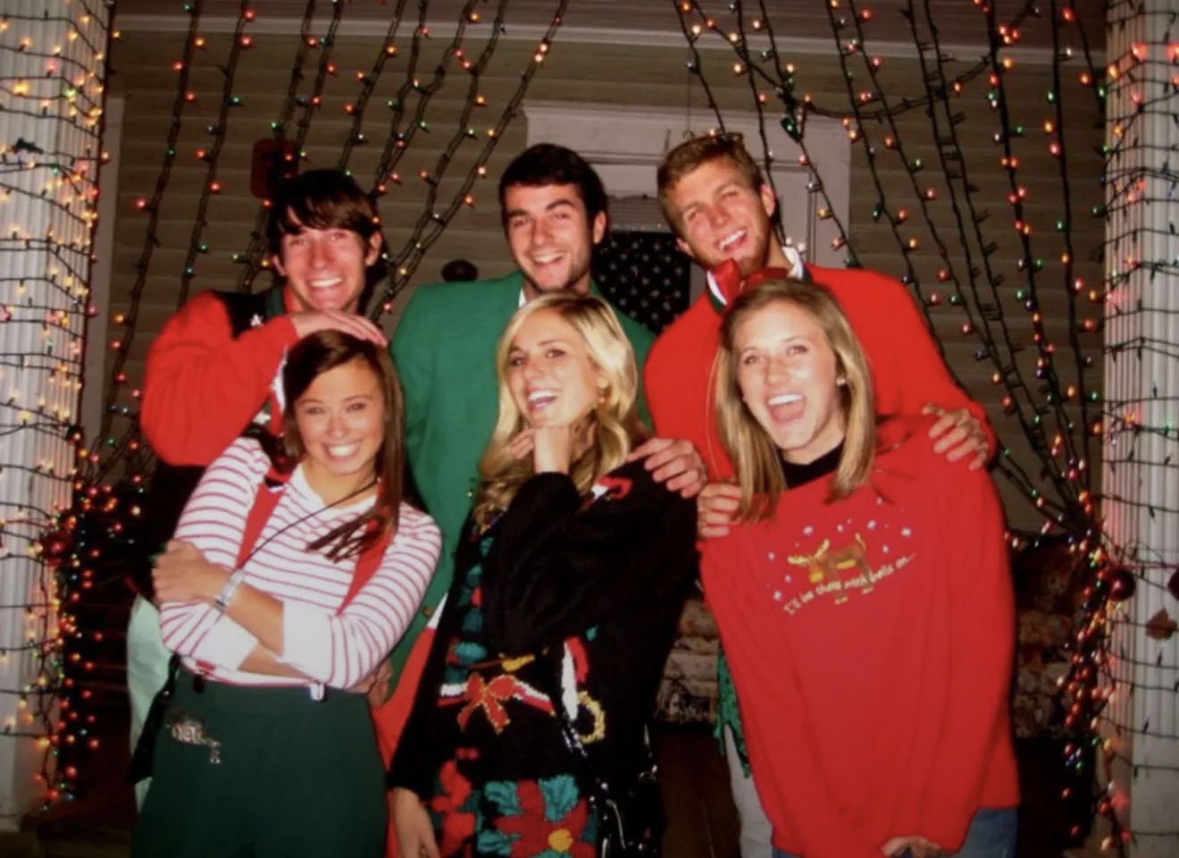 Guys and friends in Christmas sweaters under string lights at Springdale